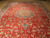 Red vintage Isfahan rug laid open on floor showing all over floral vine field
