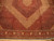 Close view of ivory and terracotta diamond bands framing the central medallion of this Persian rug