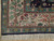 Corner detail of ivory border with woven cranes, flowering trees and teal lion guard band