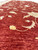 Angled field view showing natural abrash striations in red wool with scrolling gold vines