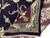Folded corner reveals dense hand-knotted back, ivory fringe and sage guard border of Agra rug