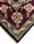 Corner detail with cream fringe, wine border palmette and blue-green guard stripe on black ground