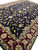 15' x 23'7" Indian rug angled, black field scrolling vines framed by burgundy floral border