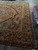 Corner of antique Sarouk carpet showing navy palmette border, ivory spandrel and side fringe