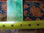 Back of rug with inventory tag reading 5620 11.2x18 and tape measure showing knot density