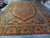 Oversize antique Sarouk photographed from the end, showing full medallion and heavy palmette border