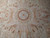 Close-up of medallion showing lilac rosette, musical trophies, quivers and soft beige and rust shading