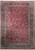 Full view of red Persian Mashad rug with all over floral field and navy border