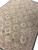 Blush border and ivory field seen at an angle across this large hand-woven Oriental rug