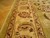 Ivory main border with vine scroll and rosettes photographed beside parquet wood flooring