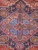 Close-up of the cornflower blue and olive geometric medallion at the center of the rug
