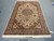 6 x 10 Tabriz Persian rug photographed flat on a concrete floor, ivory field and fringe