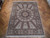 8'8" x 11'6" wool and silk rug displayed flat on herringbone parquet wood floor