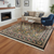 Black floral 7x8 rug styled in a bright living room with beige sofa and fireplace