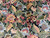 Macro detail of silk highlighted petals and olive green leaves on a jet black ground