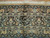 Close-up of the woven signature cartouche in the brown border of this antique Persian rug