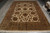 9' x 12'2" hand-knotted wool rug laid flat, cream field framed by olive flowering border