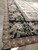 Angled corner detail showing black floral border framed by mauve scrolling guard bands