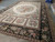 Ivory and black needlepoint rug seen from the side with 4 floral cameo panels