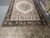 Overhead view of the 12' x 18' flat weave needlepoint rug on warehouse tile floor