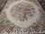 Center medallion close up showing pink, blue and lavender flowers with feathered ribbon detail