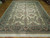 10'3" x 13'10" Pakistani floral rug photographed at an angle on light parquet flooring