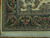 Corner close-up showing dark green acanthus border, rose blossoms and hand-tied ivory cotton fringe
