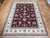 9x12 hand-knotted Tabriz design rug displayed on parquet wood floor showing ivory border and burgundy field
