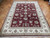 Angled view of the 8'6" x 11'6" wool and silk rug on herringbone parquet flooring