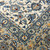 Close-up of hand-knotted wool pile where the ivory field meets the taupe palmette border