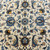 Detail of sky blue palmettes, gold saffron accents and small red flower centers on ivory