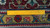 Ruler laid across the border measuring the tight hand knotted wool weave and knot density
