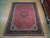 Full overhead view of hand-knotted wool area rug on light wood showroom floor