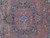 Close-up of the 8 petal rosette medallion in light blue, black and salmon red wool pile