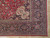 Corner detail showing navy main border, palmette spandrel and rose accents on hand-knotted wool pile