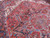 Brick red field detail showing angular palmettes, anchor pendants and ivory spandrel drawing in wool
