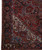 Corner view of the ivory spandrel, deep navy main border and reciprocal guard stripes