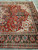 Angled corner view showing salmon palmettes, olive leaves and teal leaf cartouches on navy border