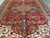 Diagonal view of medallion, navy pendants and ivory spandrels across the antique red field