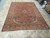 Living room sized 8'8" x 11'7" Kashan rug shown from the end on neutral stone tile