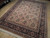 7'8" x 10' Chinese Oriental rug angled on wood floor showing deep black floral border