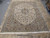 9'9" x 13' Kashan rug laid on tile floor showing complete ivory field and camel borders