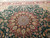 Wool and silk pile catching light around the central medallion and surrounding floral vine scroll