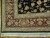 Corner detail showing berry red border, ivory guard stripes, hand-tied fringe and finely drawn floral heads