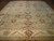 Full view of 9'9 x 13'9 Chobi Peshawar rug with sage green field and burgundy palmettes