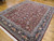 8'1 x 10' traditional Oriental rug photographed at an angle across a sunlit hardwood living room floor