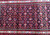 Bright light close-up of the wool pile showing navy lattice cells and multicolored rosette accents