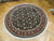 Angled view of 7 by 7 round Oriental rug with wine red border and cream fringe