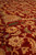 Wool pile texture close up with peach blossoms, olive leaves and lustrous brick red ground