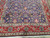 Angled corner view showing violet field, serrated leaves, palmettes and wide madder red main border